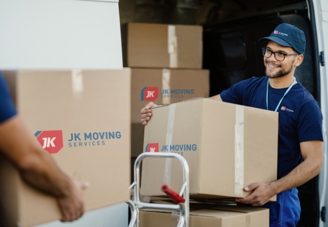 A worker accurately logs incoming inventory shipments in a well-organized warehouse.